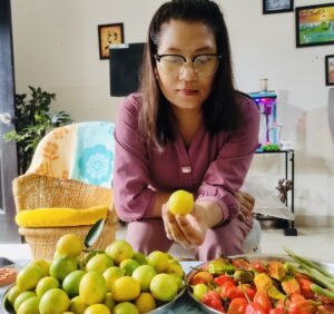 Home gardener showing freshly harvested lemons from a productive lemon plant